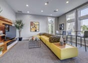 Thumbnail 26 of 33 - a living room with a yellow couch and a table with chairs