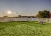 Thumbnail 20 of 33 - a yard with a white fence and a rock in the grass
