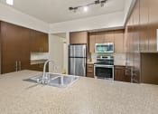Thumbnail 13 of 30 - a kitchen with wood cabinets and a granite counter top at Allez, Redmond, 98052