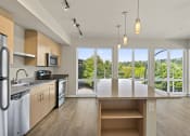 Thumbnail 14 of 30 - a kitchen with a large island and a view of the trees outside at Allez, Washington