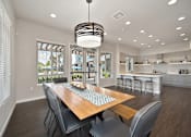 Thumbnail 11 of 31 - A modern dining room with a wooden table and chairs.
