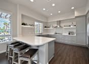 Thumbnail 6 of 31 - A kitchen with a white counter and brown stools.