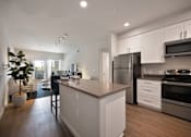 Thumbnail 19 of 31 - A modern kitchen with white cabinets and stainless steel appliances.