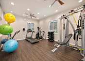 Thumbnail 12 of 31 - A well-equipped home gym with a variety of exercise equipment.