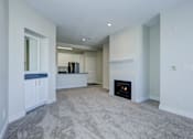 Thumbnail 44 of 45 - A living room with a fireplace and a grey carpet.