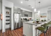 Thumbnail 2 of 34 - A modern kitchen with a wooden floor and white walls.