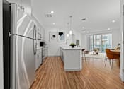 Thumbnail 5 of 34 - A modern kitchen with wooden floors and stainless steel appliances.