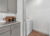 Thumbnail 10 of 34 - A kitchen with a white dishwasher and grey cabinets.