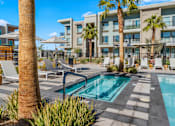 Thumbnail 20 of 34 - A pool surrounded by palm trees and chairs.