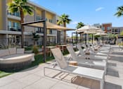 Thumbnail 21 of 34 - A sunny day at the outdoor seating area of a modern apartment complex.