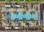 Thumbnail 22 of 34 - An aerial view of a pool surrounded by palm trees and lounge chairs.