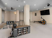 Thumbnail 30 of 34 - A room with a Fitness center and a TV on the wall.