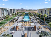 Thumbnail 33 of 34 - A pool surrounded by palm trees and apartment buildings.