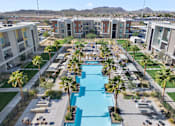 Thumbnail 34 of 34 - A large swimming pool surrounded by palm trees and lounge chairs in a residential area.