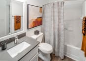 Thumbnail 14 of 38 - Bathroom with a shower curtain and a sink and a toilet at Arbor Heights, Tigard