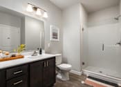 Thumbnail 11 of 35 - A bathroom with a toilet, sink, and shower.
