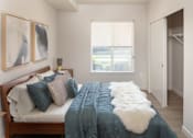 Thumbnail 9 of 34 - A bedroom with a bed, a window, and two paintings on the wall.