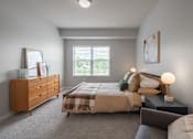 Thumbnail 8 of 35 - A bedroom with a bed, nightstand, and dresser.