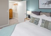 Thumbnail 3 of 34 - a bedroom with a large bed and a bathroom in the background