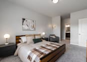 Thumbnail 9 of 35 - A bedroom with a bed, nightstands, and a chair.