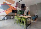 Thumbnail 30 of 34 - A modern dining area with a wooden table and green chairs.