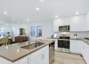 Thumbnail 44 of 51 - a kitchen with white cabinets and a large counter top