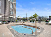 Thumbnail 19 of 29 - A small pool with a slide in the middle of a patio.