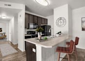 Thumbnail 2 of 29 - A kitchen with a brown chair and a white counter.