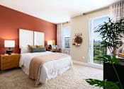 Thumbnail 19 of 24 - a bedroom with a bed and a large window