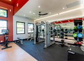 Thumbnail 6 of 24 - a gym with weights and cardio machines and a ceiling fan