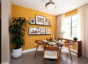 Thumbnail 17 of 24 - a dining room with a table and chairs and a plant