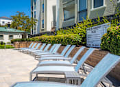 Thumbnail 5 of 31 - A row of sun loungers are arranged on a patio.