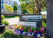Thumbnail 25 of 31 - A sign for Bridgepointe Rental Condominiums stands in front of a building.