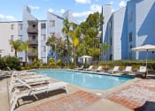 Thumbnail 11 of 53 - a swimming pool with chaise lounge chairs and umbrellas in front of an apartment building at Enclave, California