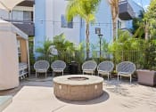 Thumbnail 17 of 53 - a group of chairs sitting around a fire pit in front of a building at Enclave, California, 90723