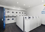 Thumbnail 46 of 53 - a laundry room with white washers and dryers at Enclave, Paramount, CA 90723
