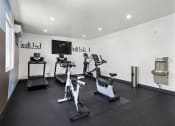 Thumbnail 28 of 53 - a room with a lot of exercise equipment and a tv on the wall at Enclave, Paramount, 90723