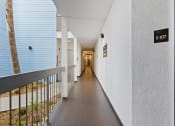 Thumbnail 35 of 53 - a hallway with a railing and a tree in the distance at Enclave, California