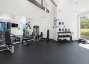 Thumbnail 30 of 53 - a large fitness room with weights and other exercise equipment at Enclave, Paramount California