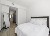 Thumbnail 43 of 53 - a bedroom with a large bed and a mirror at Enclave, Paramount, CA 90723