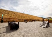 Thumbnail 32 of 33 - a group of benches in a sandy area next to a hill