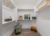 Thumbnail 10 of 36 - a walk in closet with shelves and baskets and a wooden floor and a white wall