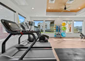Thumbnail 25 of 36 - a gym with treadmills and other exercise equipment with a view of the yard