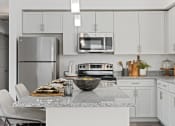 Thumbnail 4 of 36 - a kitchen with white cabinets and a marble counter top