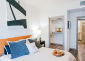 Thumbnail 12 of 36 - a bedroom with a bed and a door to a bathroom