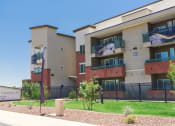 Thumbnail 16 of 36 - an apartment building with a yard and a sign in front of it