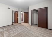 Thumbnail 24 of 50 - A room with a carpeted floor and three doors.