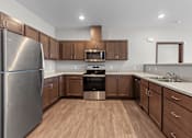 Thumbnail 8 of 50 - A kitchen with wooden cabinets and a stainless steel refrigerator.