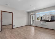 Thumbnail 10 of 50 - A room with a wooden floor and a window showing a house outside.