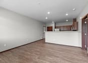 Thumbnail 12 of 50 - A large empty room with wooden floors and white walls.
